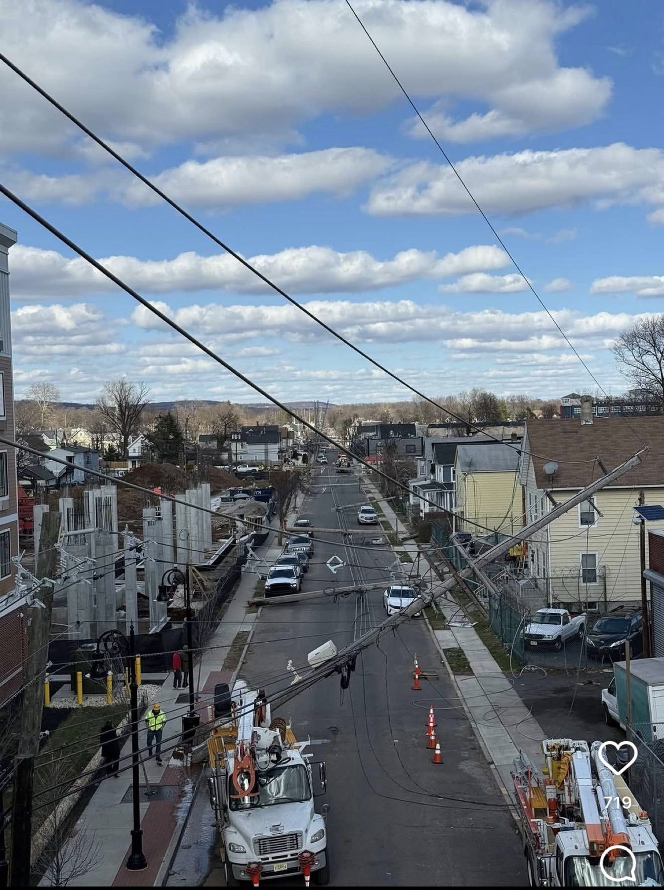 A utility pole down across a New Jersey street with trucks on scene